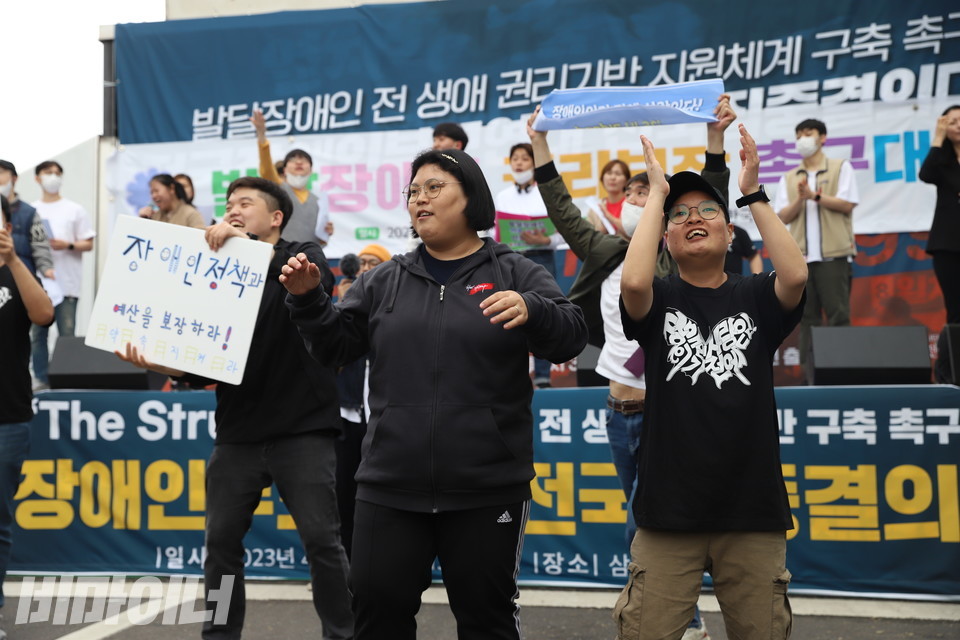 발달장애인 권리가 적힌 각종 구호를 들고 춤추는 피플퍼스트 발달장애인 활동가들. 가운데에 박경인 활동가가 있다. 사진 강혜민