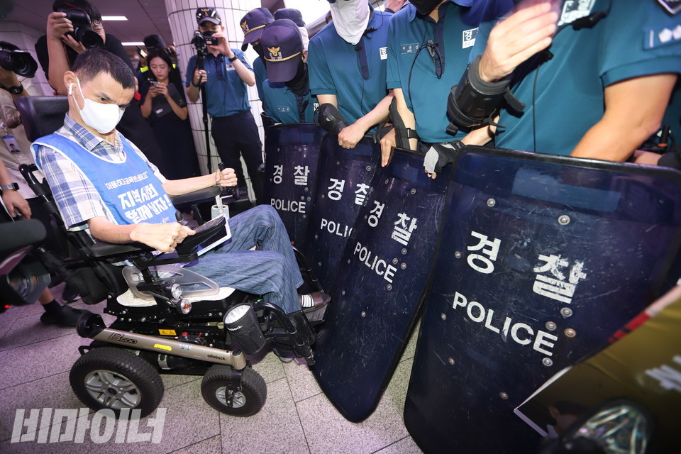 경찰들이 장애인 활동가들의 지하철 탑승을 방패로 막아서고 있다. 사진 강혜민