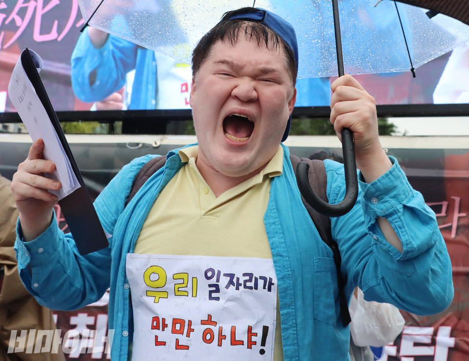 문석영 피플퍼스트서울센터 활동가가 ‘동료지원가 사업 폐지 철회를 촉구’하는 노래를 부르고 있다. 그의 가슴에는 “우리 일자리가 만만하냐!”고 적힌 피켓이 있다. 사진 하민지