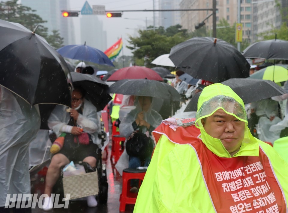 탁신 김포장애인자립생활센터 활동가는 형광 우비를 입고 결의대회에 참석했다. 사진 하민지