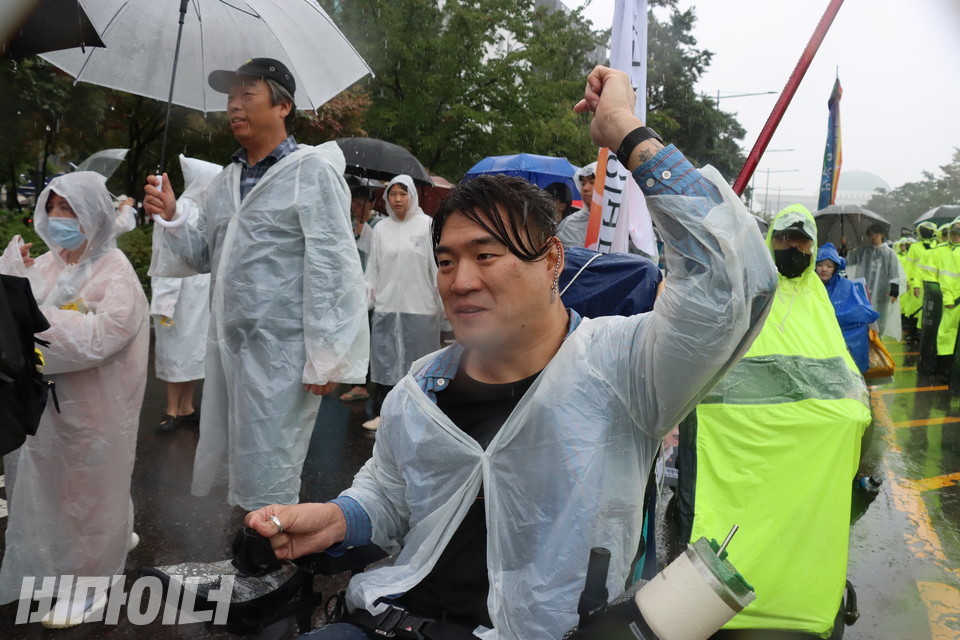 유진우 노들장애인자립생활센터 활동가가 비를 맞으며 “투쟁”을 외치고 있다. 사진 하민지