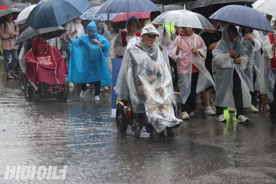 추경진 노들장애인자립생활센터 권익옹호활동가(가운데)가 빗속에서 행진 중이다. 사진 하민지
