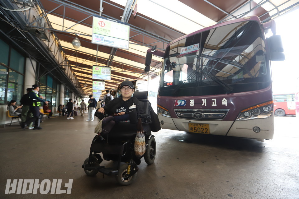 이수미 씨가 휠체어 탄 장애인은 탑승할 수 없는 고속·시외버스 앞에 서 있다. 사진 강혜민