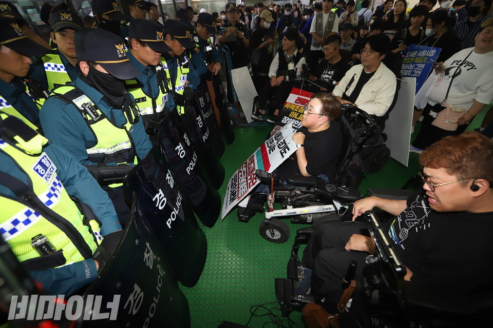 승차홈에 들어가려는 장애인들을 막아선 경찰. 그 앞에서 박김영희 대표(가운데)가 발언하고 있다. 사진 강혜민