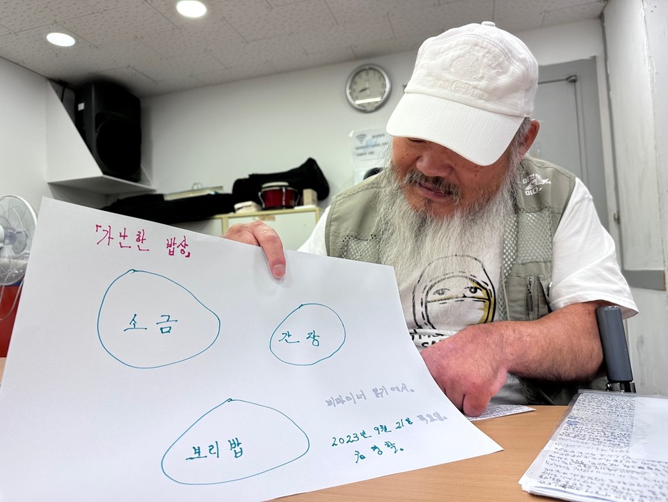 노들야학 공동교장이자 학생인 김명학 씨는 ‘가난한 밥상’을 그렸다. 보리밥에 소금, 간장이 그려져 있다. 사진 노들야학