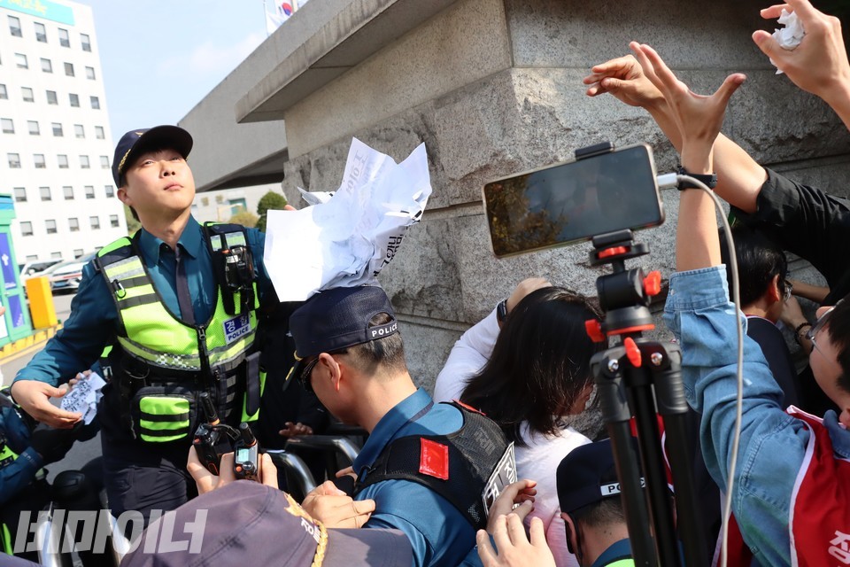경찰이 권리스티커를 모조리 떼서 구겨 던지고 있다. 사진 하민지