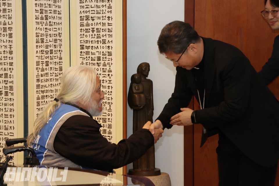 박경석 전장연 상임공동대표가 정순택 대주교와 악수하고 있다. 사진 하민지