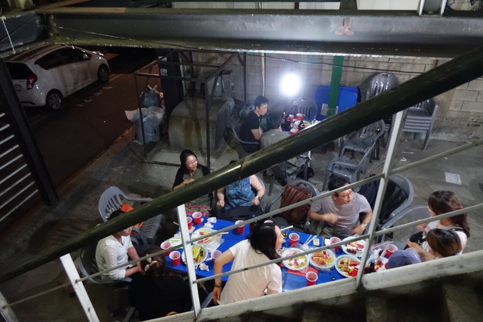 2014년, 주차장에서 열린 후원주점. 사람들이 모여 먹고 마시며 담소를 나누고 있다. 사진 김유미