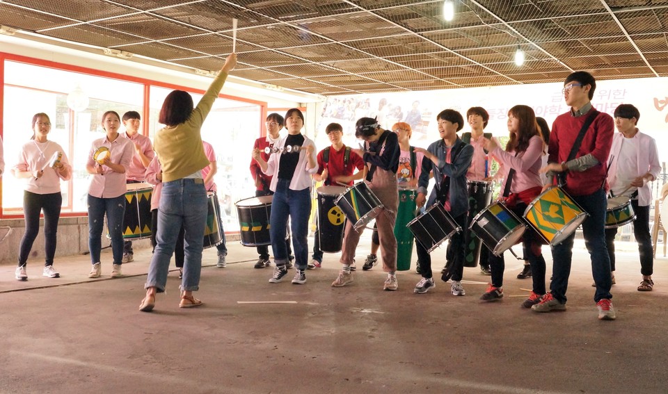 2016년, 주차장에서 열린 후원주점. 사람들이 바투카다 연주를 하고 있다. 사진 김유미