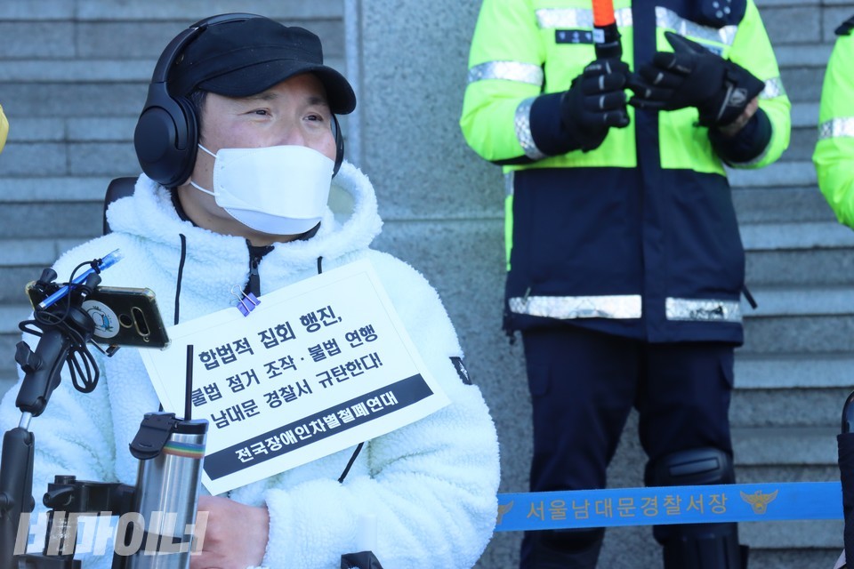 추경진 노들장애인자립생활센터 권익옹호활동가가 남대문서를 규탄하는 피켓을 들고 있다. 사진 하민지