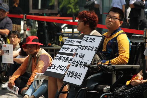 반올림 농성장에서 투쟁 중인 사람들. 활동가들이 든 피켓에 “사회적인 약속 져버린 삼성, 피해자들은 분노한다!”, “사과, 보상, 재발방지대책에 대해 성실하게 대화하라”고 적혀 있다. 사진 한명희