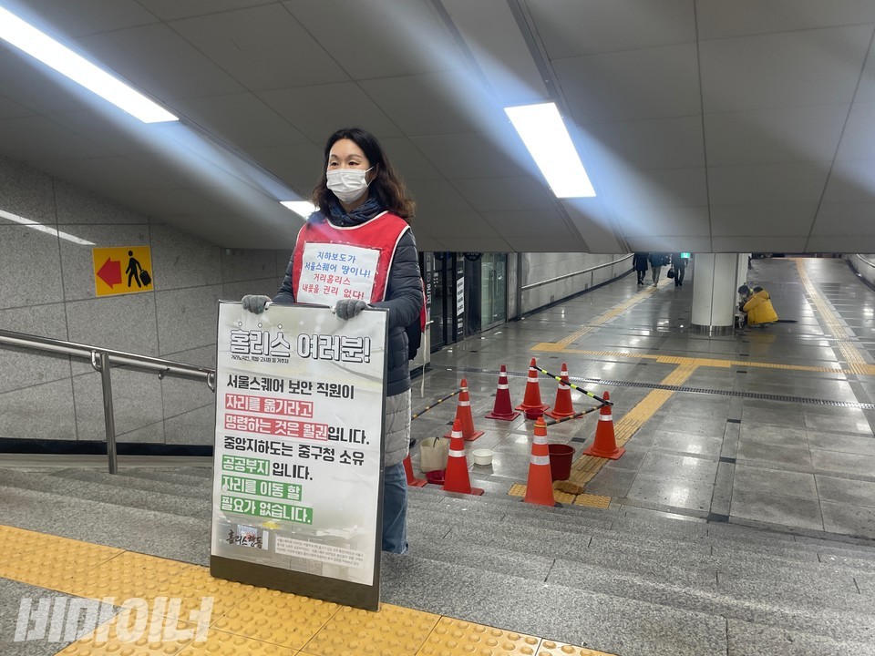 지난 14일, 홈리스야학 교사인 변미혜 청소년주거권네트워크 활동가가 서울역 앞 지하보도에서 1인 시위를 하고 있다. 피켓에는 “홈리스 여러분! 서울스퀘어 보안 직원이 자리를 옮기라고 명령하는 것은 월권입니다. 중앙지하도는 중구청 소유 공공부지입니다. 자리를 이동할 필요가 없습니다”라고 적혀 있다. 사진 하민지