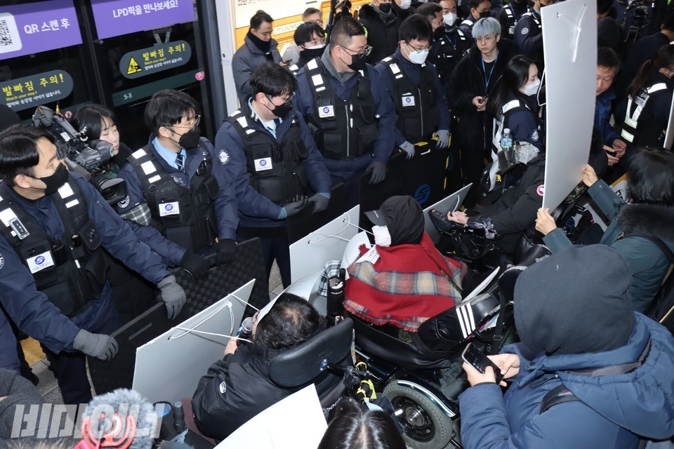 서울교통공사 직원들이 장애인 활동가들을 막아서고 있다. 사진 하민지
