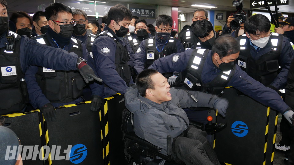 한 활동가가 방패로 무장한 서울교통공사 직원들에 의해 강제퇴거당하고 있다. 사진 하민지