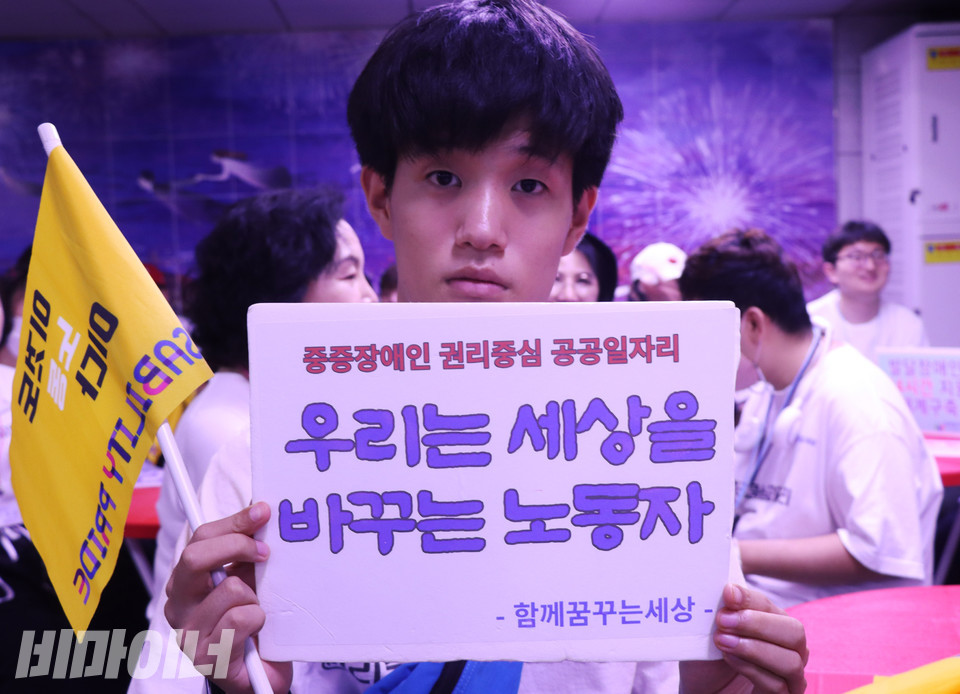 경기도 권리중심공공일자리 노동자가 “우리는 세상을 바꾸는 노동자”라고 적힌 피켓을 들고 있다. 사진 강혜민 