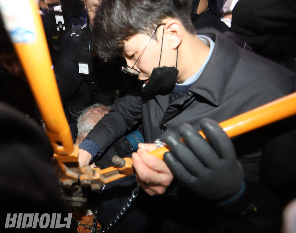 서울교통공사 직원이 절단기로 박경석 대표의 목에 감긴 쇠사슬을 자르고 있다. 사진 강혜민