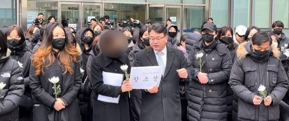 특수교사 ㄱ씨가 경기도교육청 고문변호사인 김기윤 변호사와 함께 항소장을 들고 있다. 김기윤 변호사는 ㄱ씨의 법률대리를 맡고 있다. 사진 경기교사노동조합 