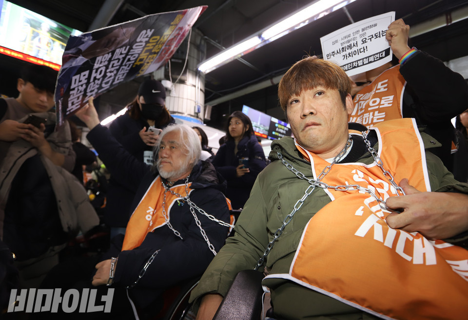 장애인 활동가들이 연행을 대비해 쇠사슬을 몸에 감고 있다. 사진 강혜민 