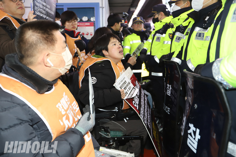 6일 아침 8시, 1호선 서울역 승강장. 전장연이 ‘58차 출근길 지하철 탑니다’를 진행하기 위해 모였다. 문애린 활동가가 열차 문을 가로막은 경찰에게 항의하고 있다. 사진 강혜민
