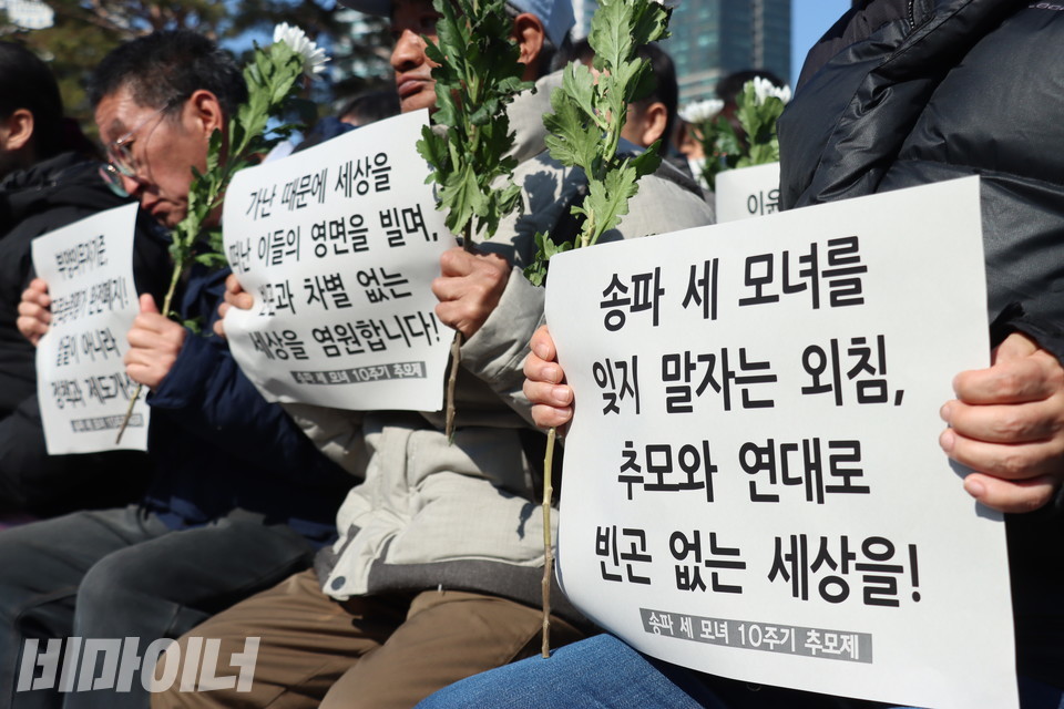 송파 세 모녀 10주기를 추모하는 피켓을 들고 있는 동자동 쪽방 주민들. 사진 강혜민  