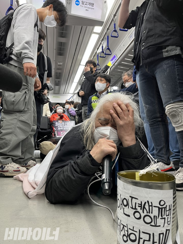지난 2022년 6월 5일 진행된 지하철 행동에서 바닥을 기고 있는 박경석 전장연 상임공동대표. 사진 비마이너 DB.