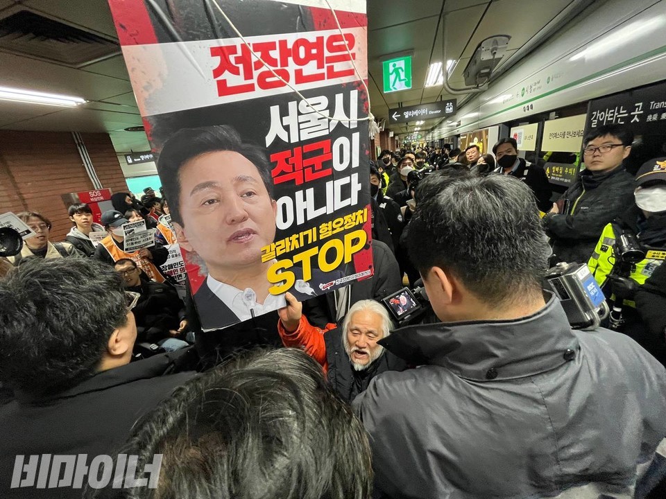 박경석 대표가 ‘전장연은 서울시 적군이 아니다. 갈라치기 혐오정치 STOP’이라고 적힌 피켓을 높이 들고 있다. 사진 김소영