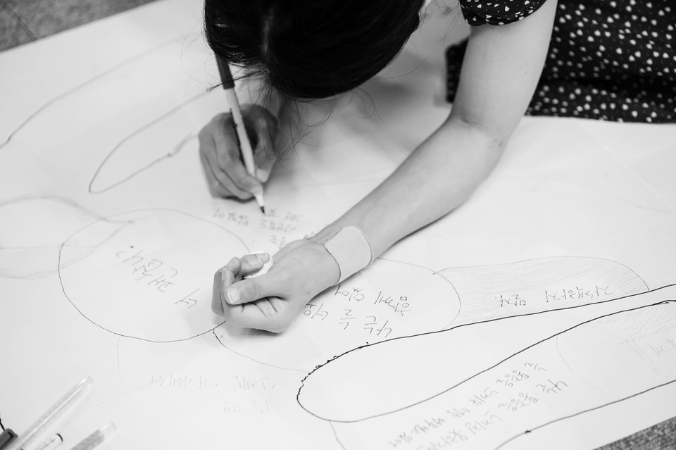 ‘질병과 함께 춤을’ 구성원이 몸 워크샵에서 아픈 몸에 대한 말을 쓰고 있다. 사진: 혜영