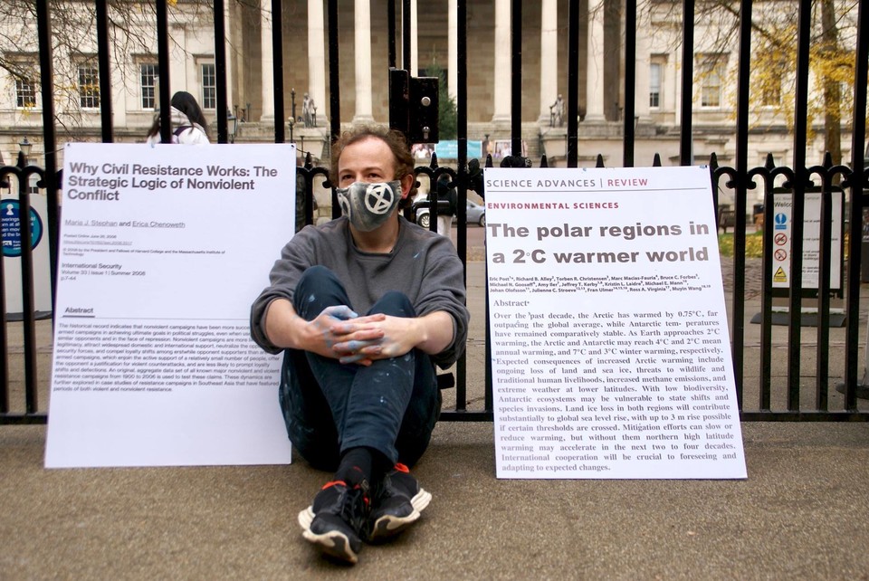 과학자반란 시위가 열렸던 옥스퍼드대학교에서 마이크가 기후위기 관련 논문 출력물과 함께 거리에 앉아 있다. 사진 Extinction Rebellion