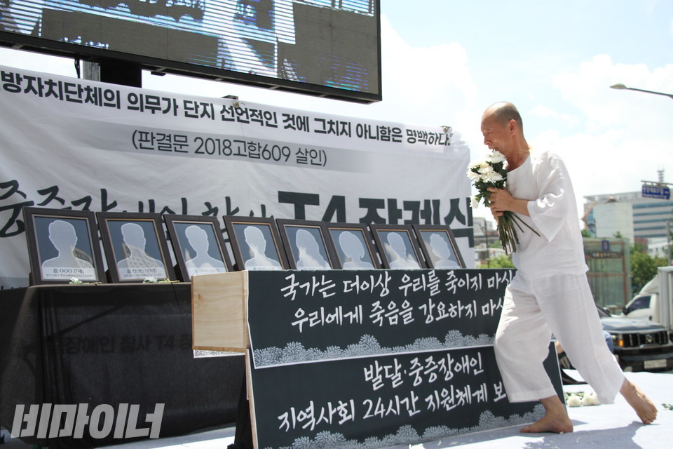 2022년7월1일. 발달·중증장애인 참사 T4 장례식에서 이삼헌 씨가 국화 다발을 든 채 추모굿을 펼치고 있다. 사진 이슬하