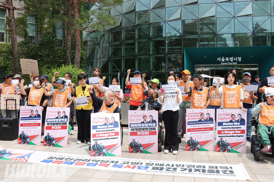 기자회견 참가자들이 주먹을 높이 들고 구호를 외치고 있다. 사진 김소영