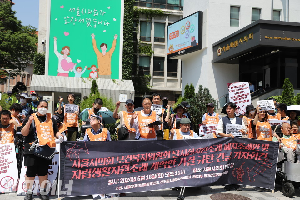 18일 오전 11시, 서울장애인차별철폐연대(아래 서울장차연) 등이 서울시의회 본관 앞에서 탈시설지원조례 폐지조례안과 자립생활지원조례 개정안 가결을 규탄하는 기자회견을 열고 있다. 사진 김소영