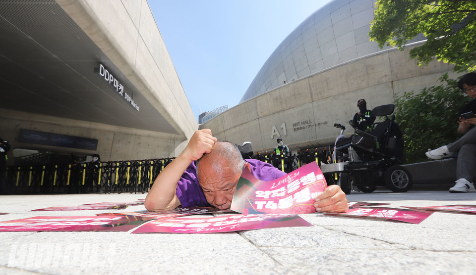 이규식 서울장차연 대표가 DDP 앞에서 포체투지를 하고 있다. “오세훈의 약자동행은 T4동행이다”라고 적힌 피켓을 들고 있다. 사진 강혜민