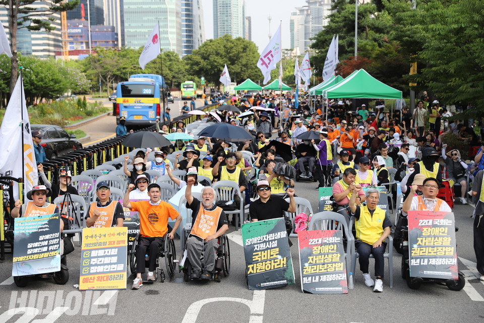 1일 오후, 국회 앞에서 열린 제6회 장애등급제 ‘진짜 폐지’ 결의대회 참가자들이 주먹을 높이 들고 구호를 외치고 있다. 사진 김소영