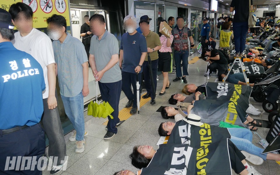 열차에서 내린 시민들이 다이인 행동을 하는 활동가들을 쳐다보며 지나가고 있다. 사진 하민지