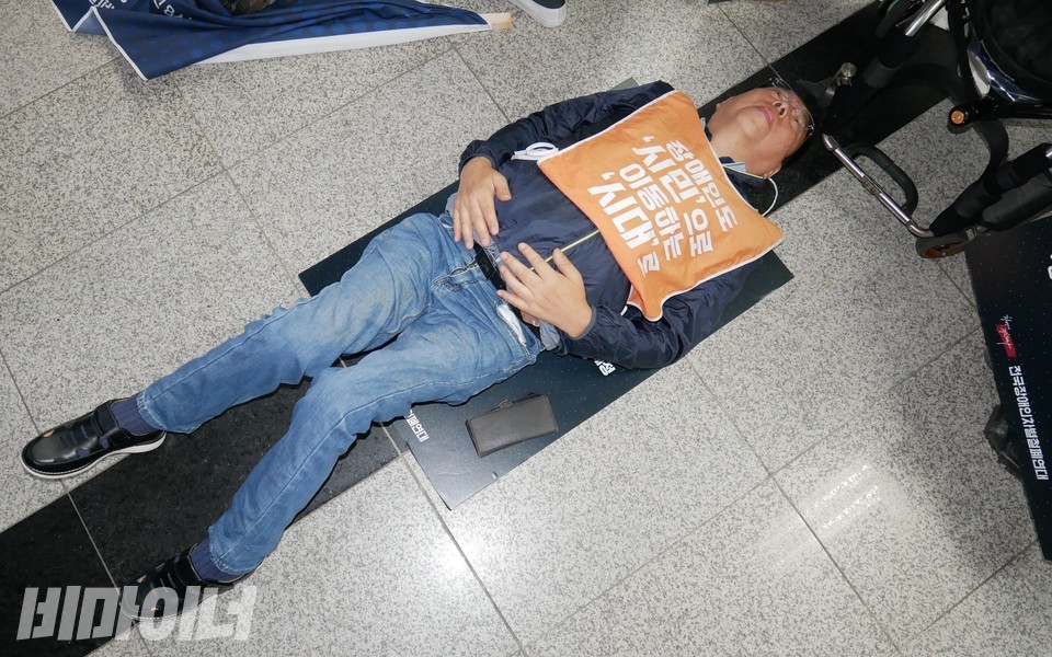 권달주 전장연 상임공동대표가 다이인 행동을 하고 있다. 사진 하민지