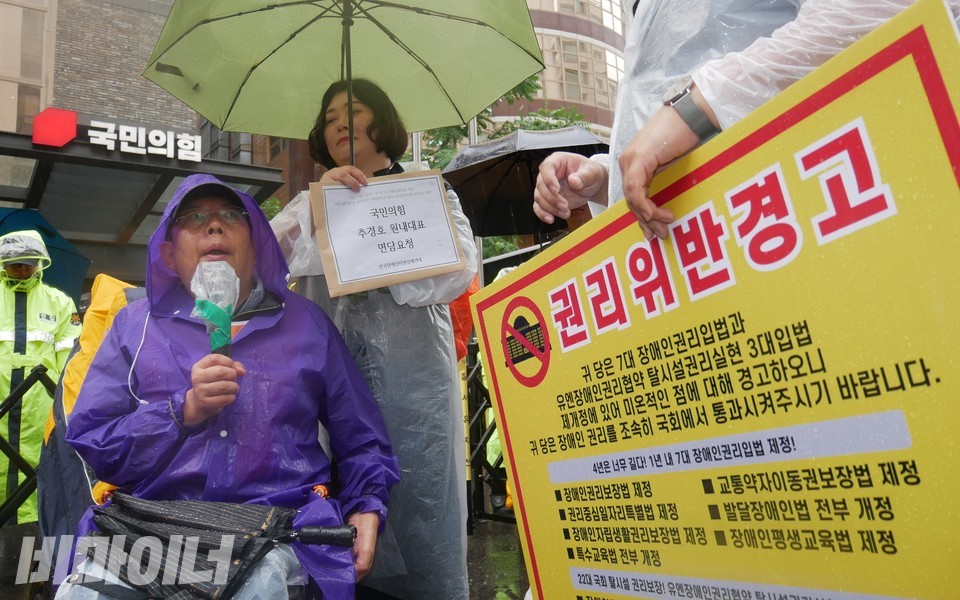 활동가들이 국민의힘 당사 앞에서 추경호 국민의힘 원내대표에게 면담요청서를 전달하려 하고 있다. 오른쪽에 “권리 위반 경고”라고 적힌 피켓이 보인다. 사진 하민지