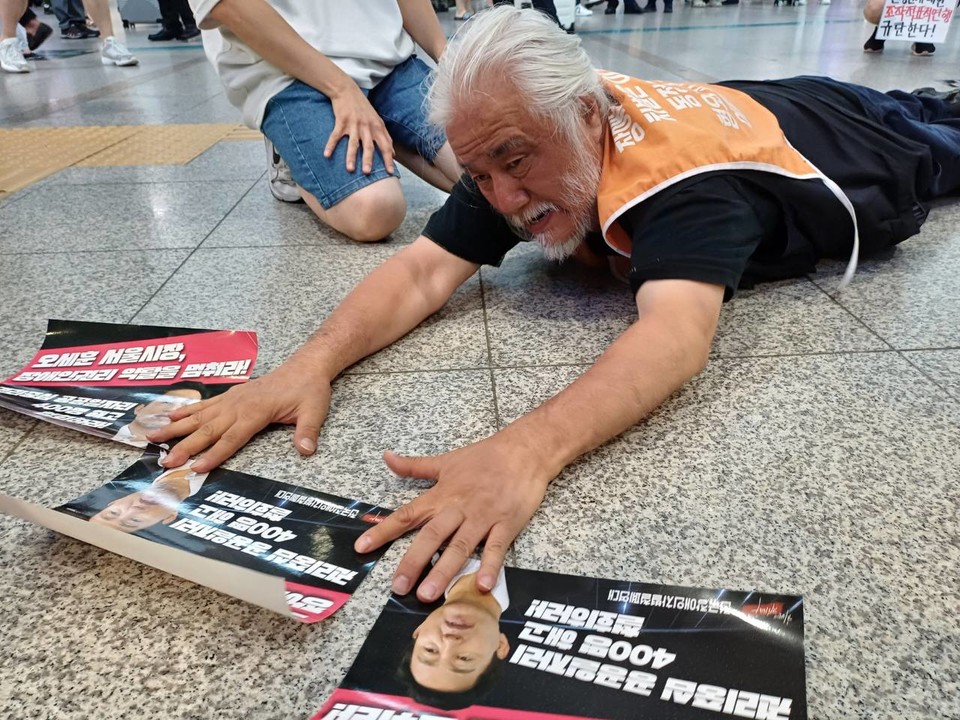 박경석 전장연 상임공동대표가 서울역 대합실에서 포체투지를 하고 있다. 사진 하민지