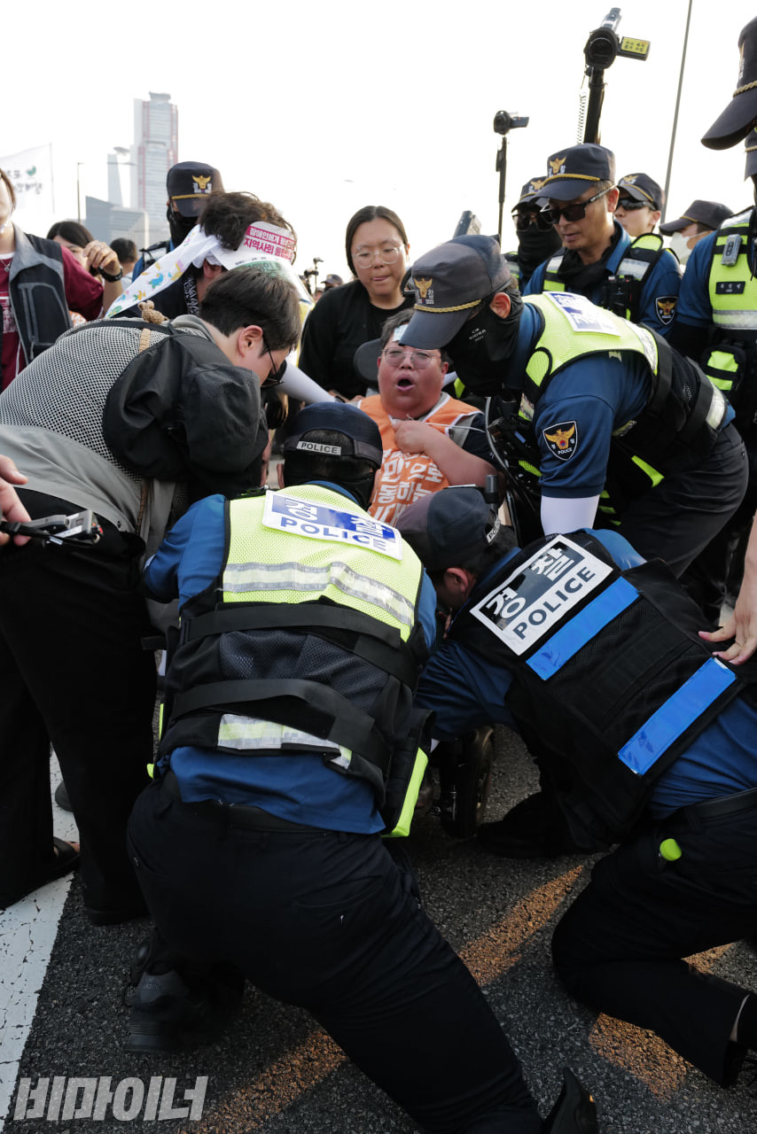 경찰이 이형숙 서울장애인차별철폐연대 대표의 휠체어를 붙잡으며 진압하고 있다. 사진 최인기