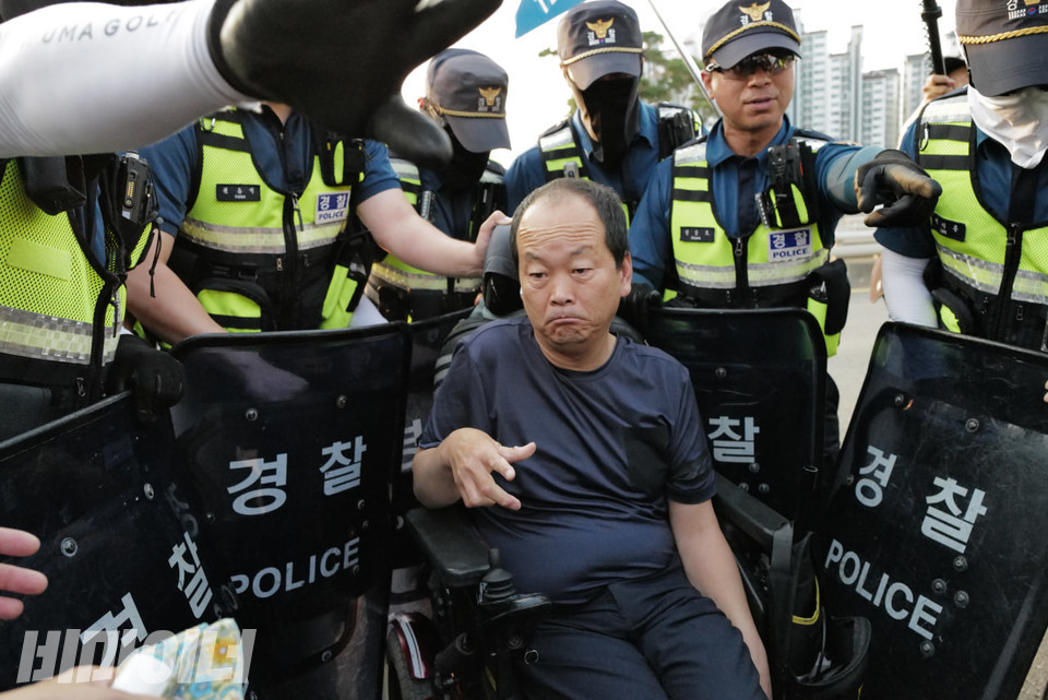 경찰이 방패로 둘러싸자 장애인 활동가가 당혹스러운 표정을 지어 보이고 있다. 사진 최인기 