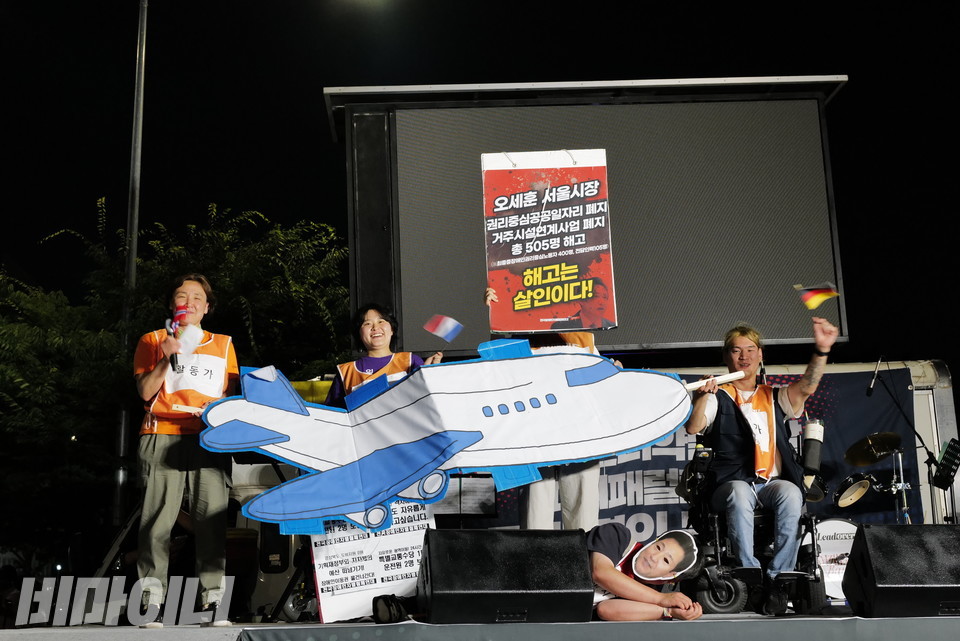 전장연은 8월 파리 패럴림픽 일정에 맞춰 장애인권리약탈을 전 세계에 알리기 위해 출국할 예정이다. 활동가들이 이를 알리는 파리패럴림픽 특사단 출정을 알리는 퍼포먼스를 하고 있다. 바닥에는 오세훈 서울시장의 가면을 쓴 활동가가 쓰러져 있다. 사진 최인기