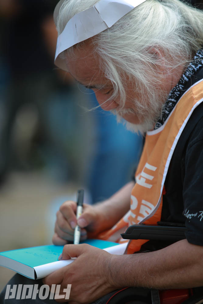 박경석 전장연 대표가 최근 출간한 책 《출근길 지하철 - 닫힌 문 앞에서 외친 말들》에 저자 사인을 하고 있다. 사진 최인기