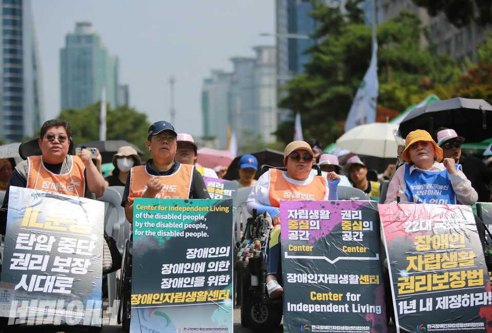 전동행진 사전대회로 진행된 ‘장애인자립생활운동 총궐기대회’에 참여한 활동가들이 “투쟁”을 외치고 있다. 사진 최인기