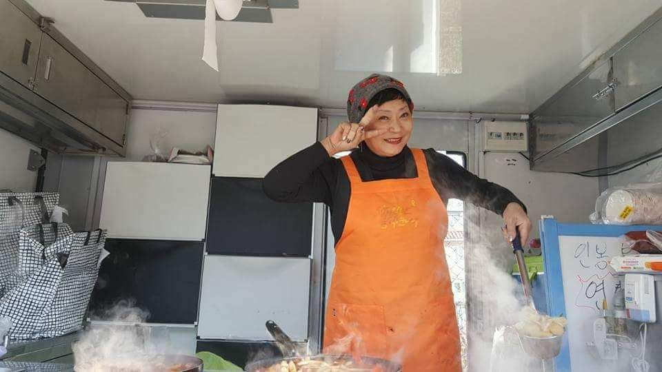 ‘십시일반 음식연대 밥묵차’ 유희 대표가 밥차 트럭에서 국을 푸면서 브이(V)를 하고 있다. 사진 김소연