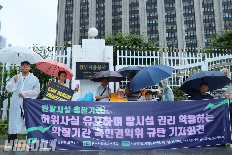 18일 오전 11시, 쏟아지는 폭우 속 서울장애인차별철폐연대(아래 서울장차연)는 정부서울청사 본관 앞에서 기자회견을 열고, 국민권익위원회(아래 권익위)를 “허위사실 유포로 탈시설권리를 약탈하는 악질기관”이라고 규탄했다. 사진 김소영