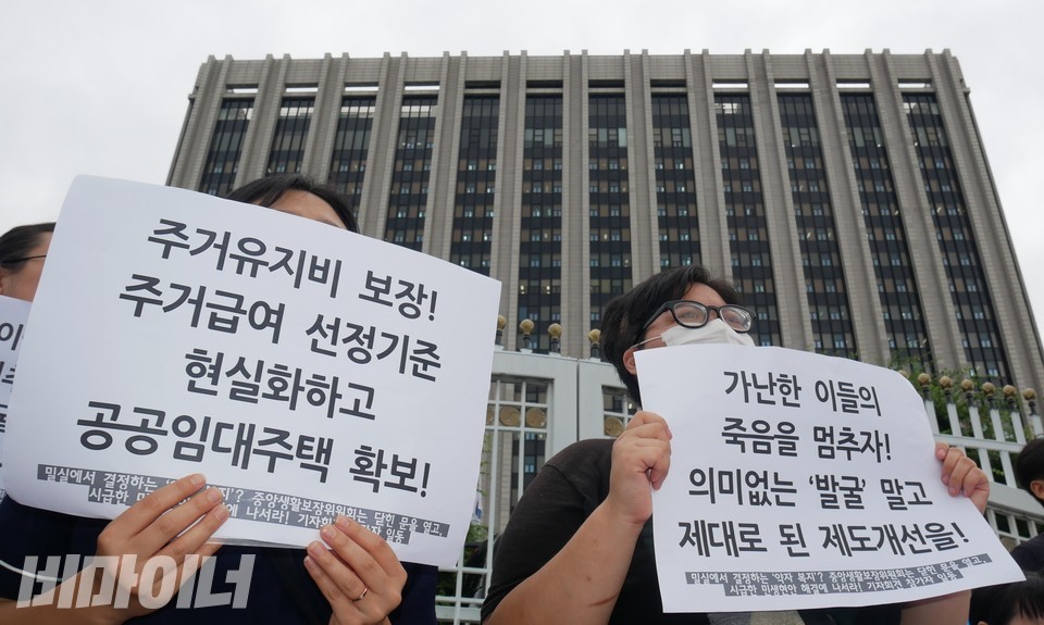 피켓을 들고 있는 기자회견 참여자들 뒤로 정부서울청사 건물이 보인다. 사진 하민지