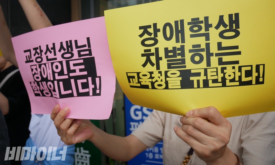 7월 18일 인권위 앞 기자회견 현장. 한 참여자가 “교장선생님 장애인도 학생입니다!”, “장애학생 차별하는 교육청을 규탄한다!”라고 적힌 피켓을 들고 있다. 사진 하민지