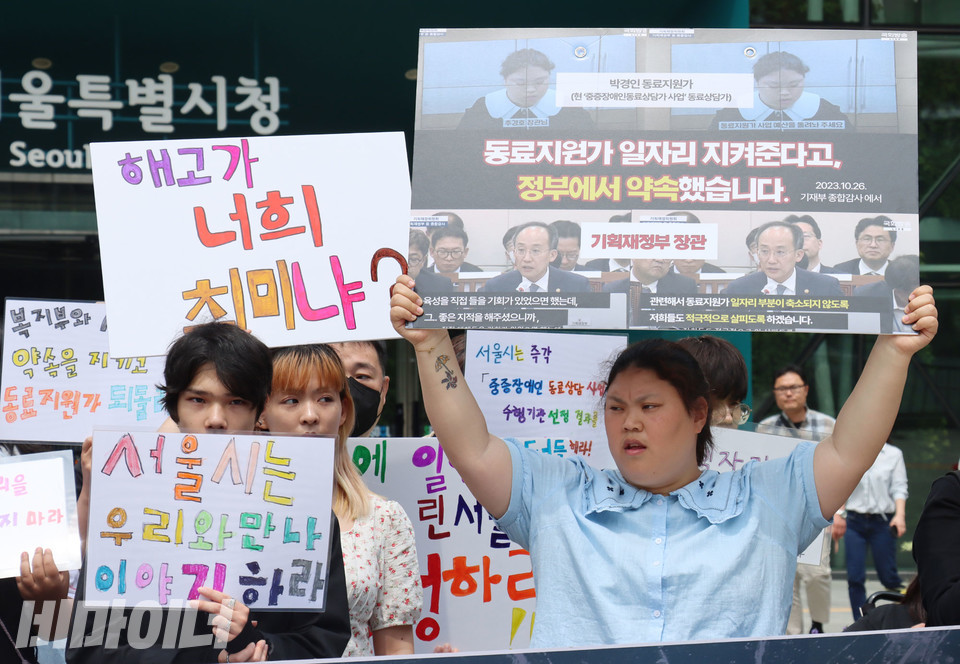 지난 4월 30일 서울시청 앞에서 ‘동료지원가 사업 폐지 대응 공동행동’이 동료지원가 고용승계 약속을 지키지 않은 서울시와 보건복지부를 규탄하는 기자회견을 진행하고 있다. 박경인 피플퍼스트서울센터 활동가가 국정감사에서 “동료지원가 일자리가 축소되지 않도록 살피겠다”고 한 추경호 전 기획재정부 장관 발언이 담긴 피켓을 들고 있다. 사진 김소영