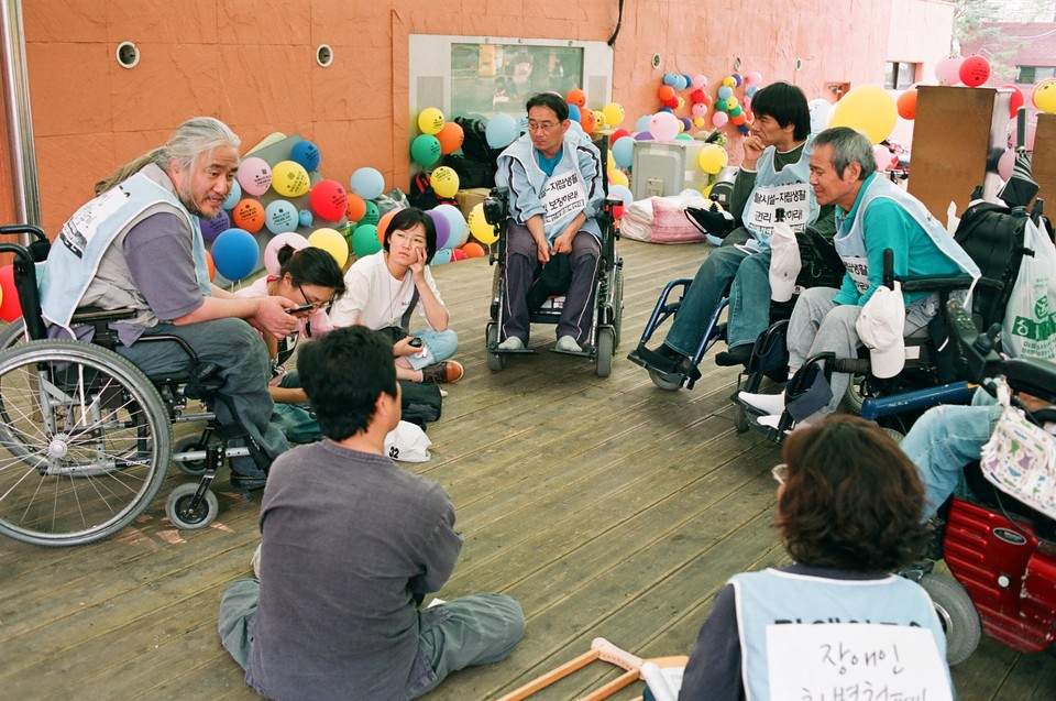 2009년 6월 마로니에공원으로 석암베데스다요양원 거주인 8명이 짐을 싸들고 나온 날, 대책회의를 하고 있다. 맨 오른쪽에 있는 사람이 김진수 대표. 사진 제공 김유미 