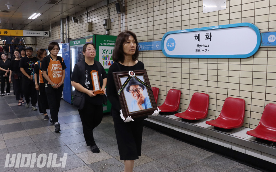 2일 아침, 고인의 영정을 들고서 활동가들이 전국장애인차별철폐연대가 매일 아침 출근길 선전전을 하는 혜화역 승강장에 들어서고 있다. 사진 강혜민