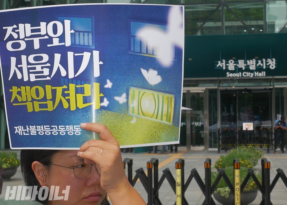 이재임 빈곤사회연대 활동가가 “정부와 서울시가 책임져라”라고 적힌 피켓을 들고 있다. 사진 하민지